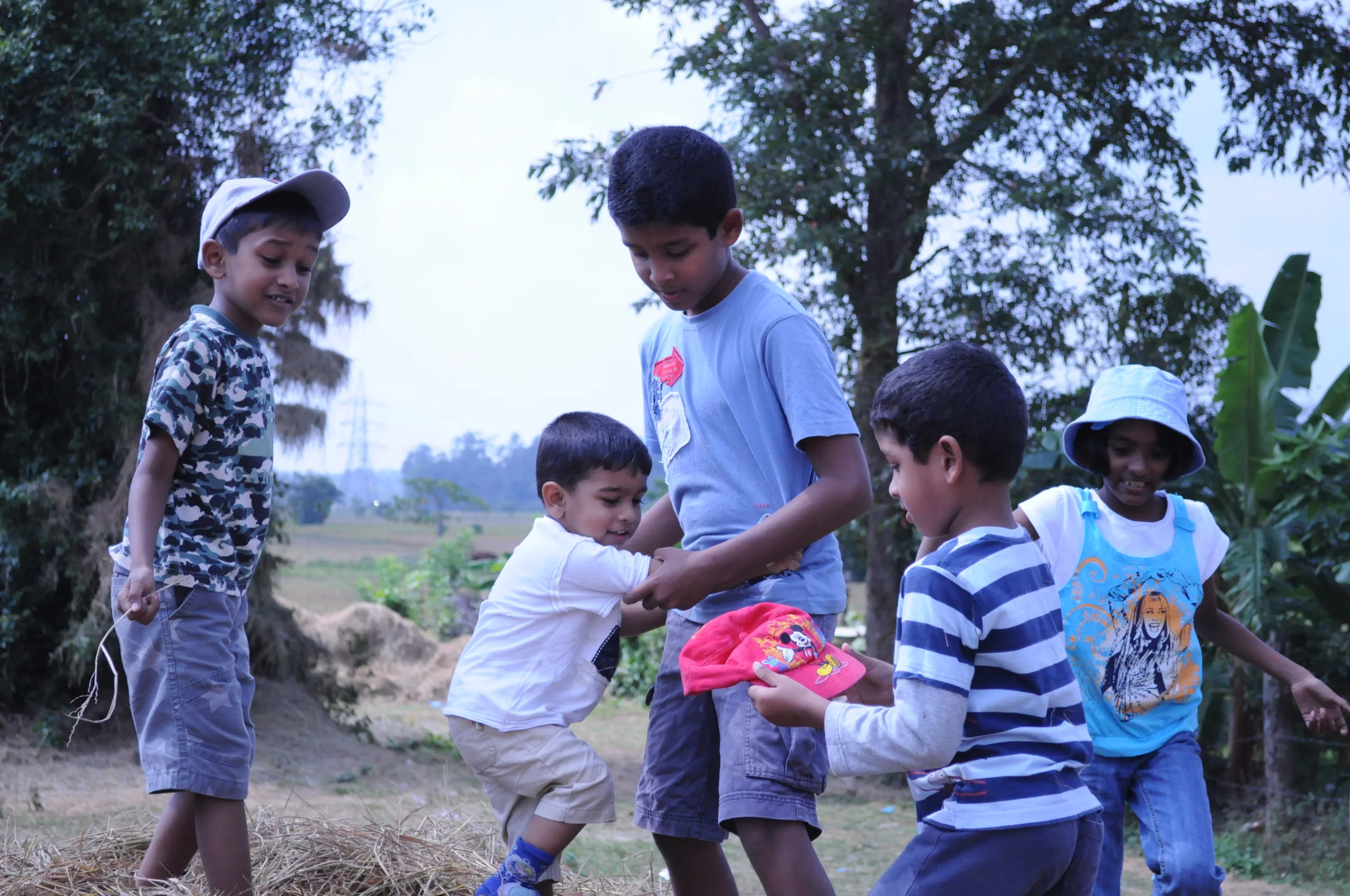 Children playing together around a haystack
