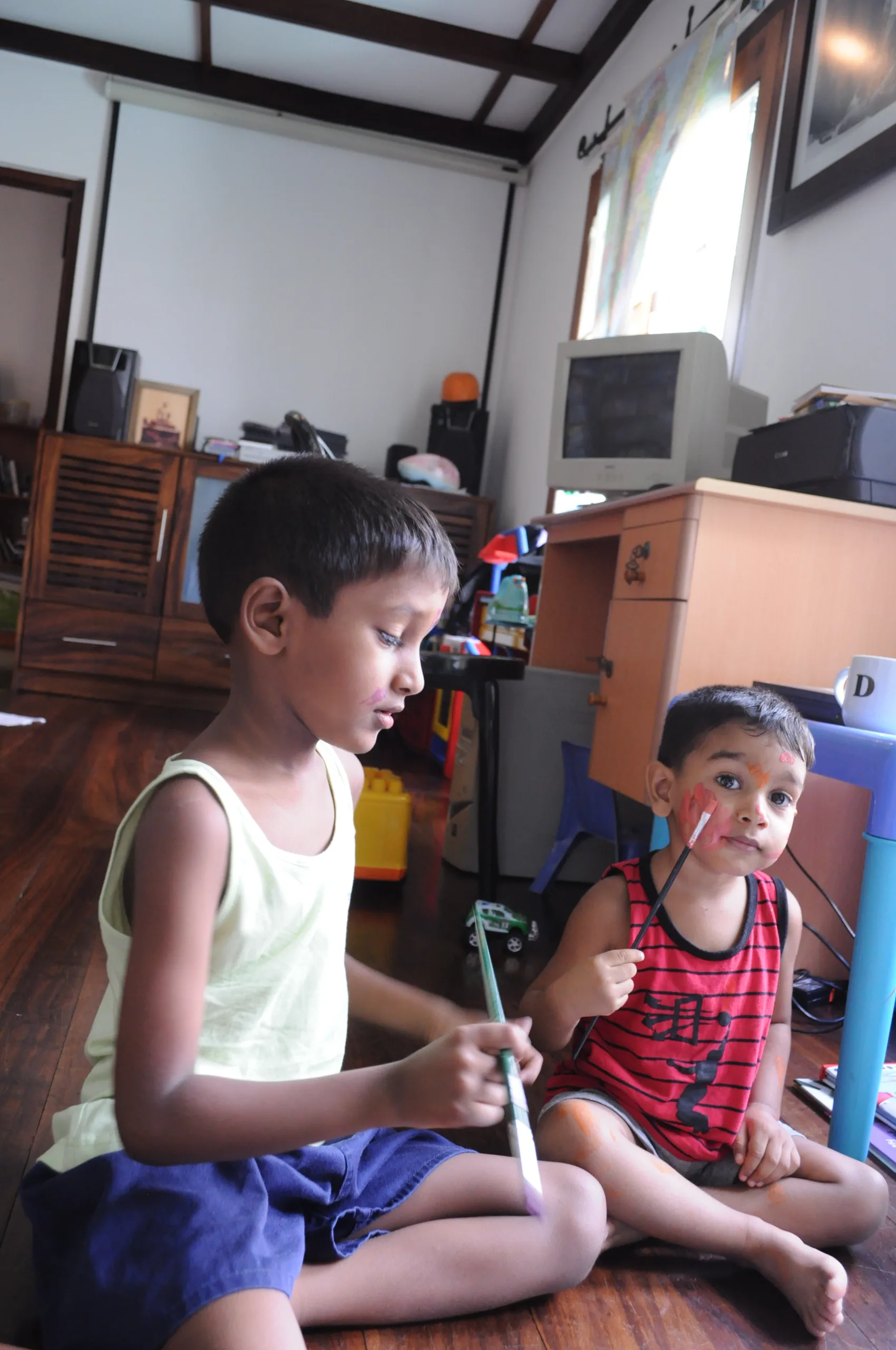 Two children with paintbrushes during a face-painting activity